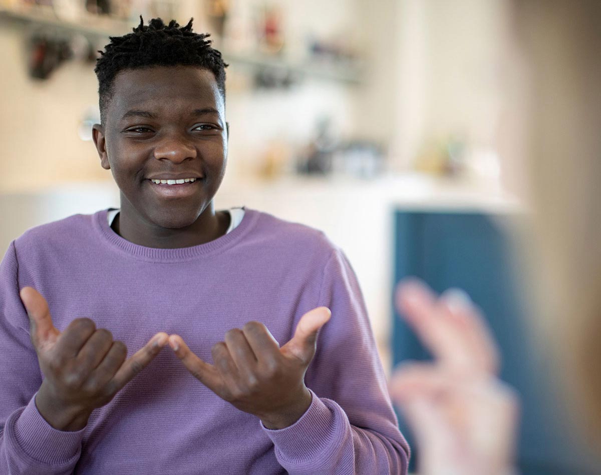 Afro-amerikanischer Junge spricht in Gebärdensprache