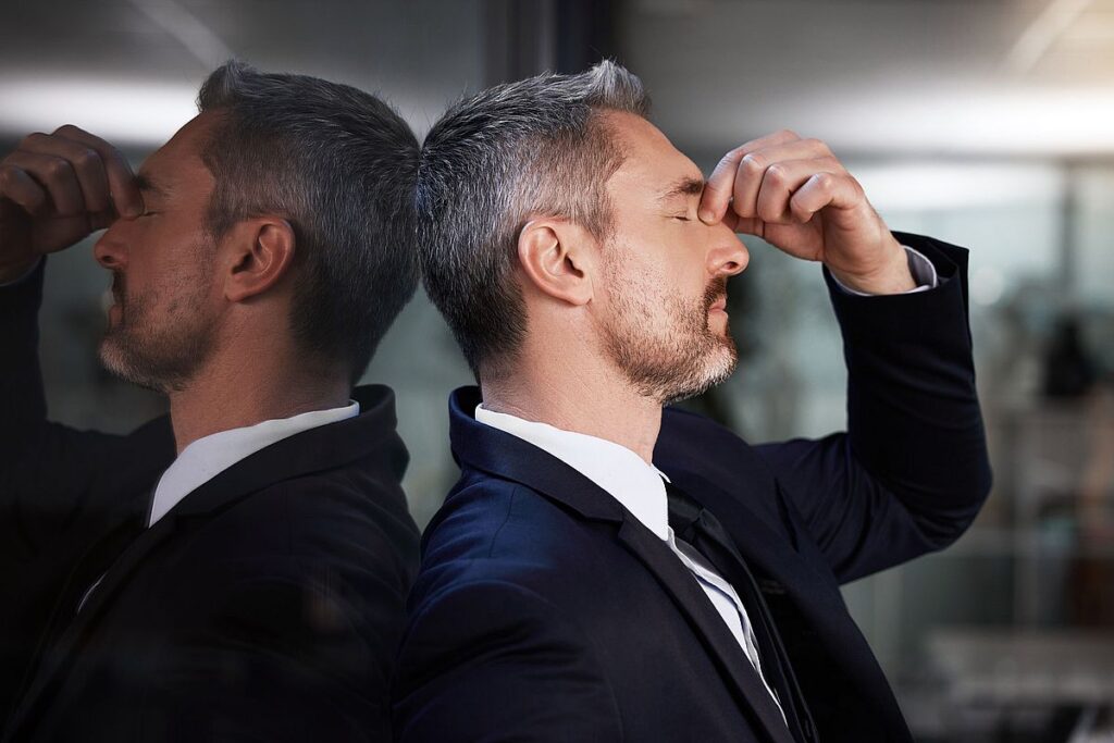 Window, business man and stress or headache, burnout and overworked in office. Senior male, entrepreneur and ceo frustrated, mental health and leader with depression, pain and tired in workplace Gestresster Geschäftsmann