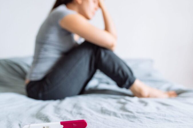 Traurige Frau mit negativem Schwangerschaftstest